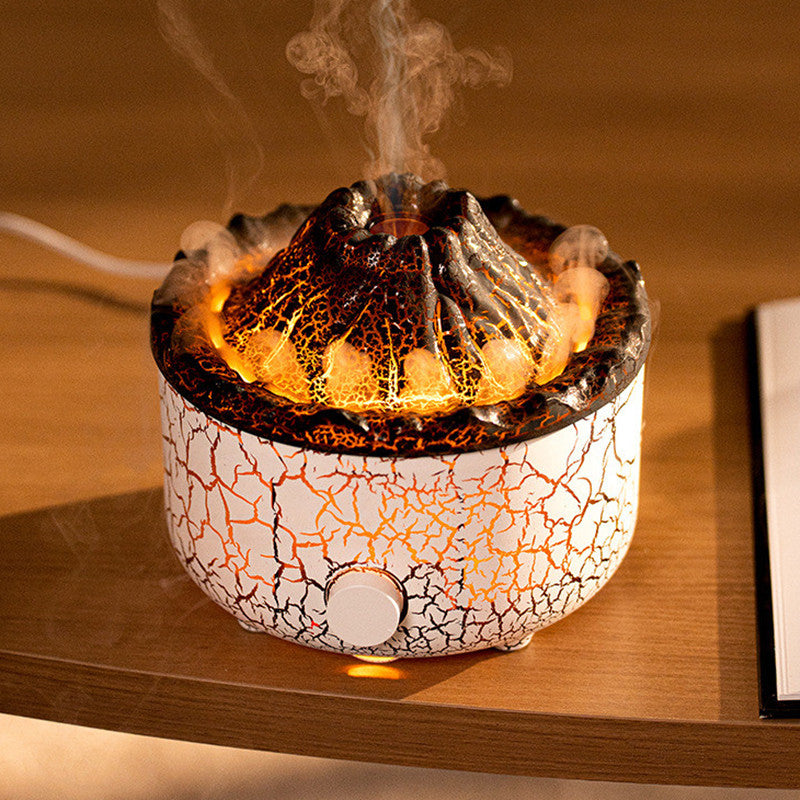 Volcano-shaped humidifier with white and black crackle finish, emitting glowing orange light and mist on a wooden table.