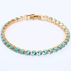 Gold-tone hip-hop tennis bracelet featuring a row of round, light blue micro-inlaid zircon stones with a clasp.