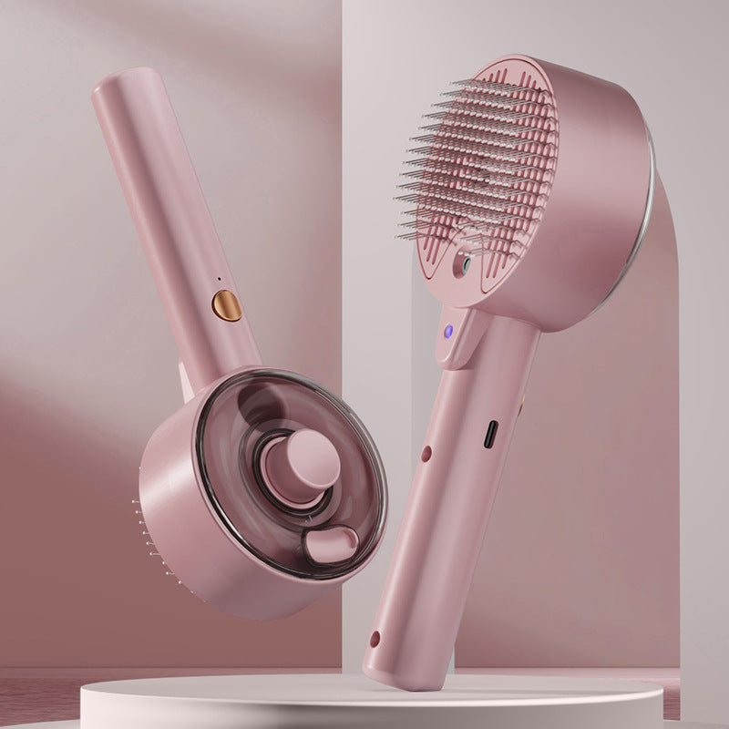 Two pink, handheld steam pet grooming brushes with metal bristles, gold buttons, and sleek, modern plastic design.