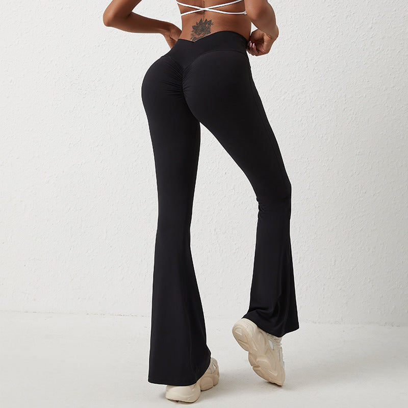 Back view of black, high-waisted, flared yoga pants with a gathered "scrunch" detail for a hip-lifting effect.