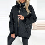 Woman wearing a black, diamond-quilted hooded coat with a full-length zipper, ribbed cuffs, and drawstring details.