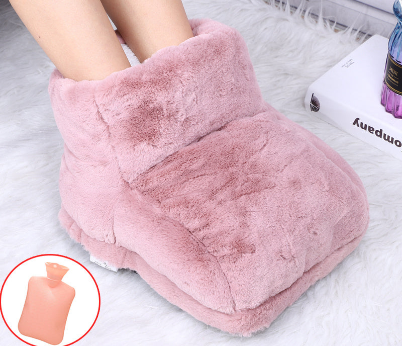 Feet inside a plush, dusty-pink faux fur electric foot warmer with an inset image of a small hot water bottle.