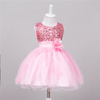 Pink baby dress featuring a sequin bodice, satin waistband with a flower accent, and a layered tulle tutu skirt.