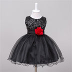 Black sleeveless baby dress with sequined bodice, satin waist, red flower accent, and full tulle skirt on a mannequin.