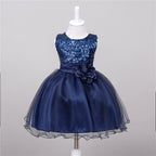 Navy blue baby dress with a sequined bodice, satin waist, flower detail, and a full tulle-layered skirt on a mannequin.