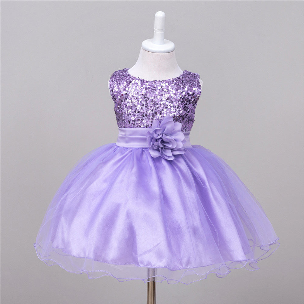 Lavender baby dress with sequined bodice, satin waist sash, fabric flower accent, and a layered tulle skirt.