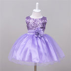 Lavender baby dress with sequined bodice, satin waist sash, fabric flower accent, and a layered tulle skirt.