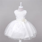 White baby flower girl dress with sequin bodice, satin waistband, and full tulle skirt featuring a floral accent.