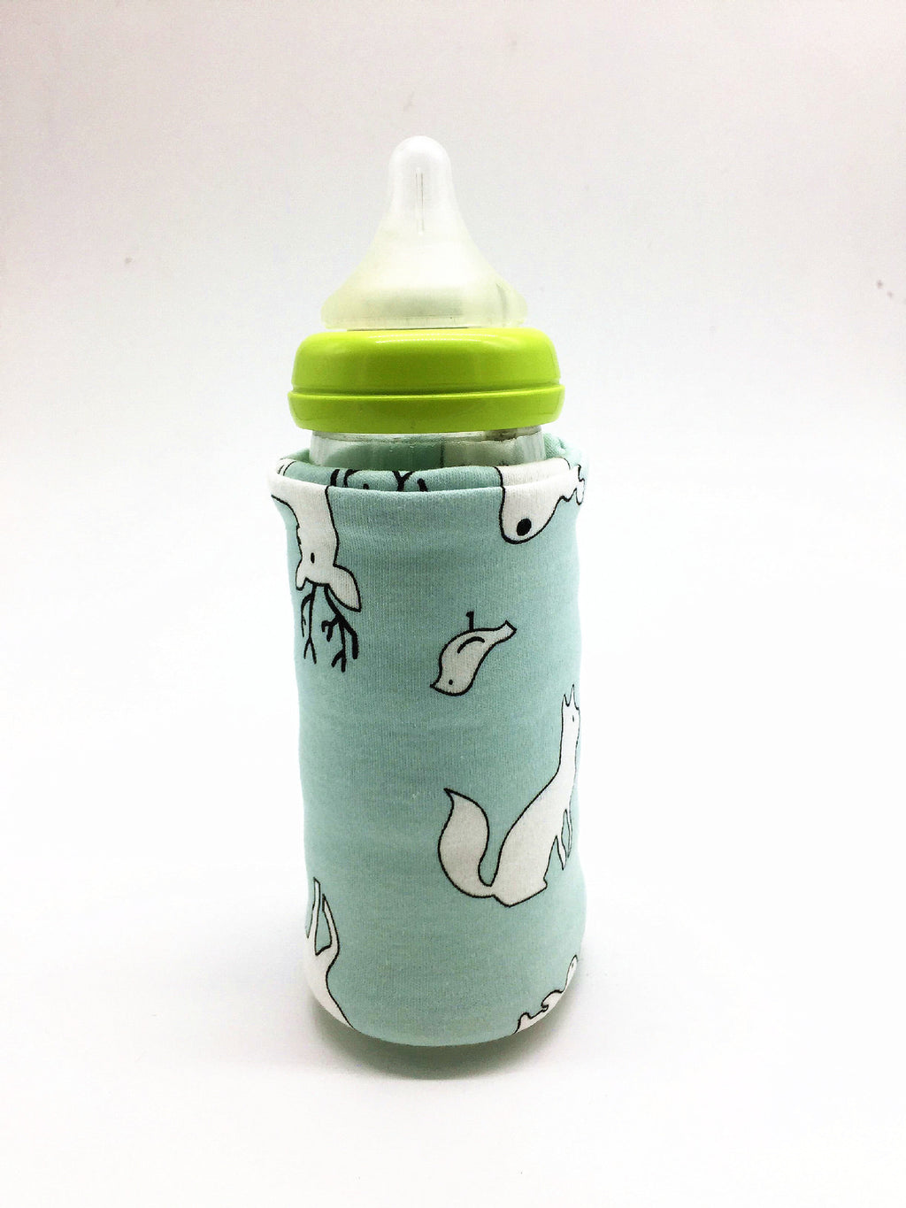A baby bottle with a green cap inside a light blue fabric sleeve featuring a white woodland animal print.