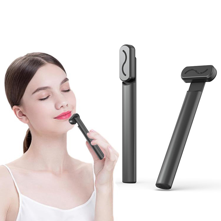 Woman uses a black, handheld LED facial rejuvenation massager wand with a sleek, minimalist design.