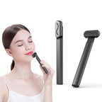 Woman uses a black, handheld LED facial rejuvenation massager wand with a sleek, minimalist design.