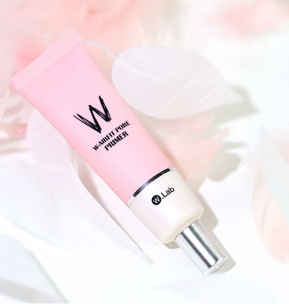 Pink W.Lab W-Airfit Pore Primer squeeze tube with a silver cap, set against a soft, white and pink feathery background.