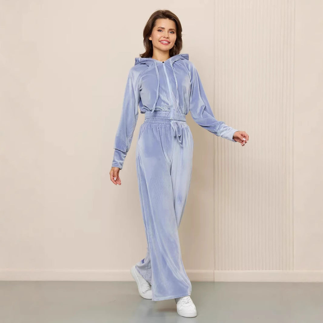 Woman wearing a light blue velvet zip-up hooded jacket and matching wide-leg drawstring trousers set.