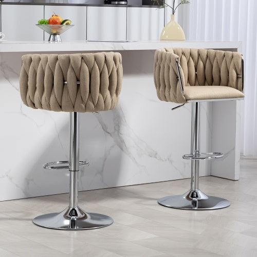 Two beige fabric, woven-back swivel bar stools with adjustable chrome pedestal bases and footrests at a kitchen island.