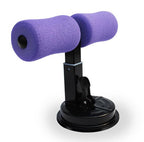 Purple foam sit-up bar trainer with a black metal frame and a sturdy suction cup base for floor mounting.