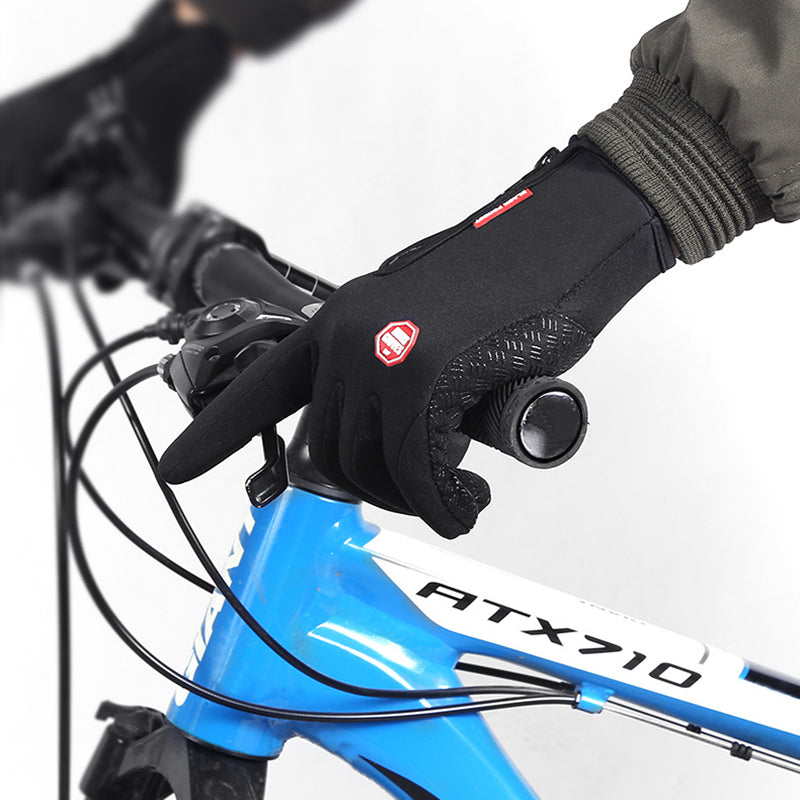 Black waterproof winter cycling gloves with touch-screen fingertips and textured grip, worn on handlebars.