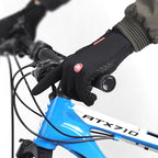 Black waterproof winter cycling gloves with touch-screen fingertips and textured grip, worn on handlebars.