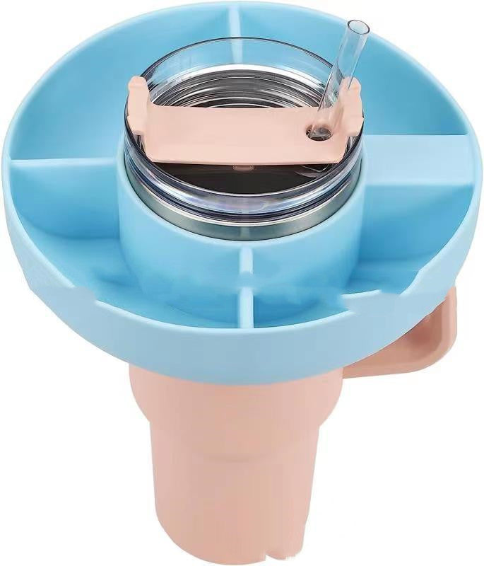 Light blue silicone 4-compartment snack ring attached to a light pink tumbler cup with a clear straw.