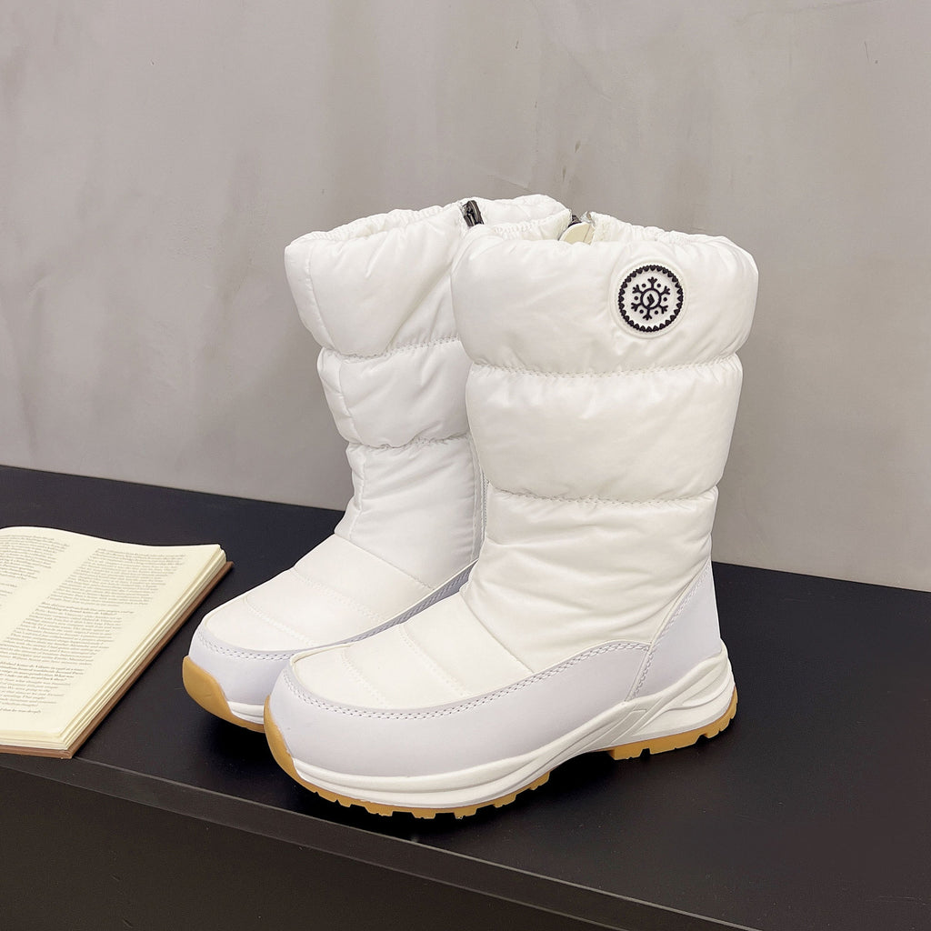 White, mid-calf quilted snow boots featuring a round snowflake emblem and durable, thick rubber soles.