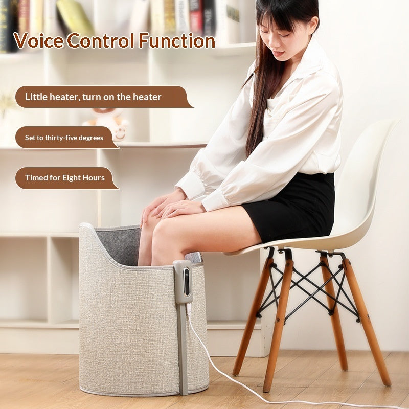 A woman uses a beige, fabric-covered cylindrical under-desk foot warmer with voice control and a digital display.