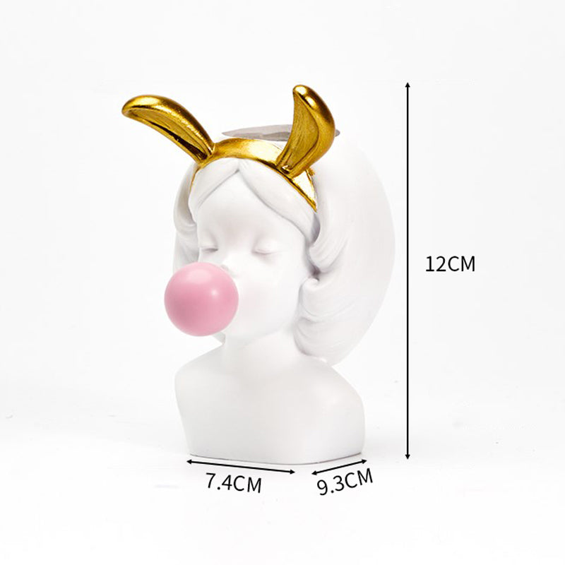 White resin bust vase of a girl blowing a pink bubble, wearing gold bunny ears, with labeled height and width dims.