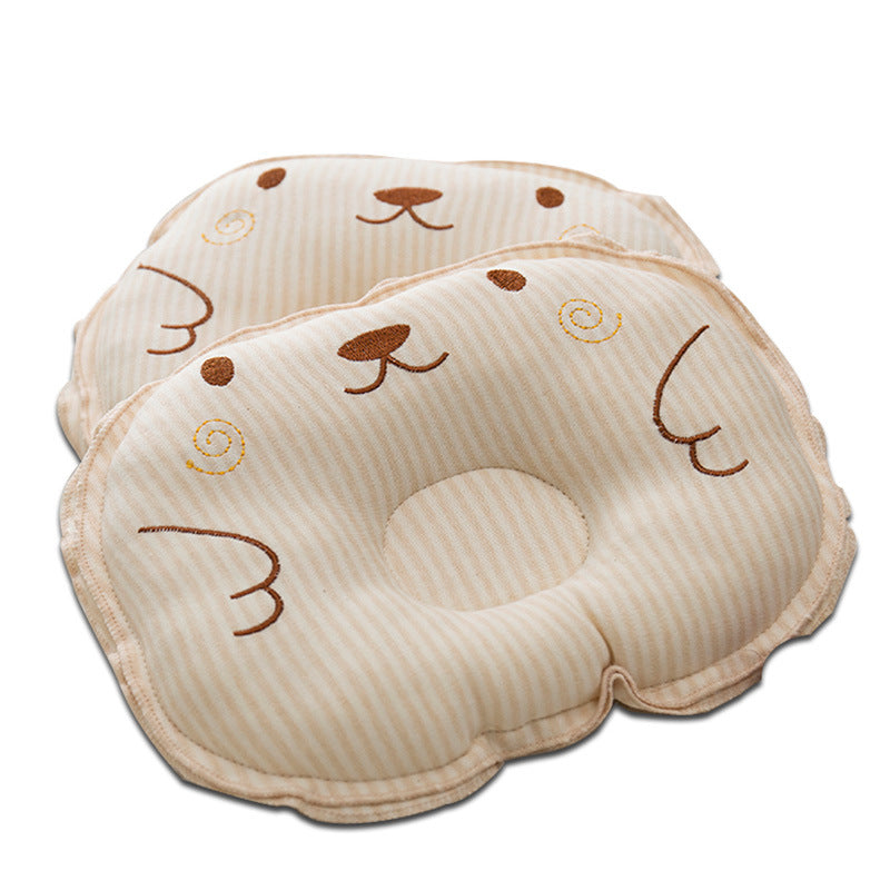Two beige-and-white striped baby pillows with embroidered bear faces and ergonomic head support indentations.