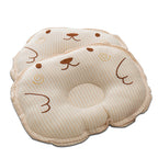 Two beige-and-white striped baby pillows with embroidered bear faces and ergonomic head support indentations.