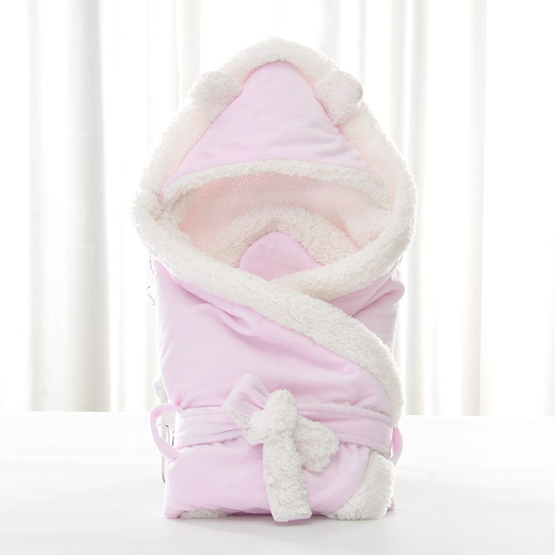 Pink plush newborn swaddle blanket with a sherpa-lined bear-ear hood and matching tie-front sash.