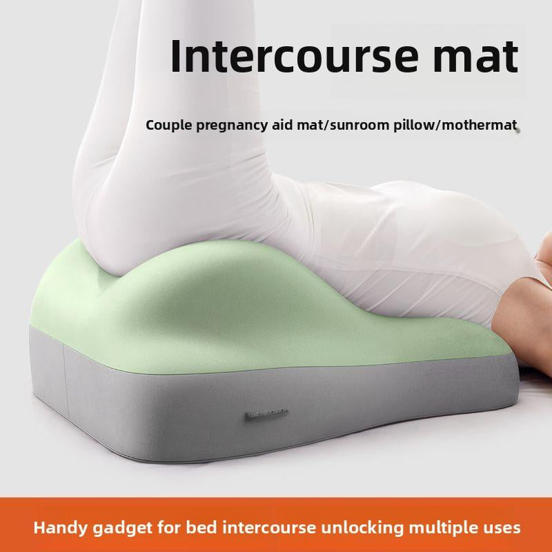 A person using a contoured, light green and grey foam support cushion to elevate their hips while lying down.