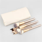 A set of 24 makeup brushes with champagne gold handles and a cream-colored leather carrying case on a white background.