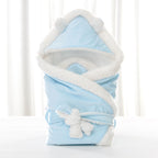 Light blue baby swaddle blanket with fluffy white fleece trim, bear-ear hood, and a plush bow tie closure.