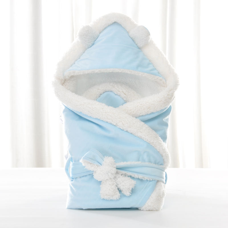Light blue baby swaddle blanket with fluffy white fleece trim, bear-ear hood, and a plush bow tie closure.