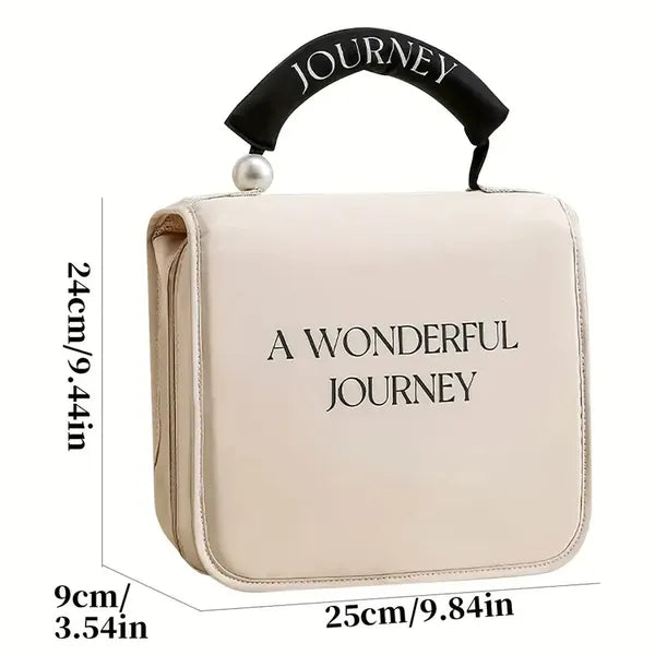 Beige portable travel cosmetic bag with black handle, pearl accent, and "A WONDERFUL JOURNEY" text. Measurements shown.