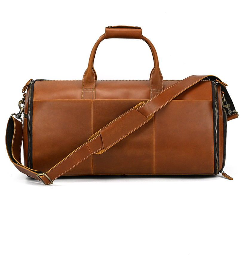Tan vintage leather duffel bag with dual handles, detachable shoulder strap, and side zippers on a white background.
