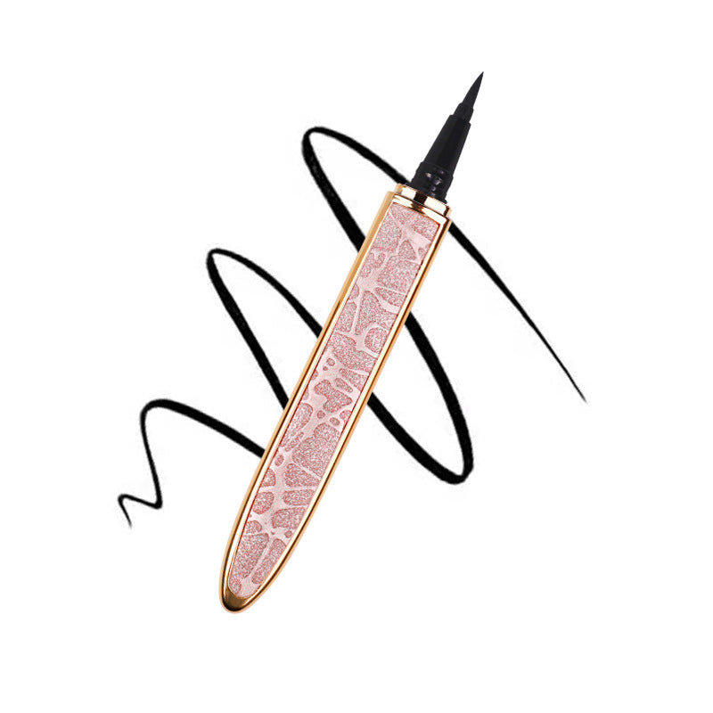 Rose gold glitter self-adhesive eyeliner pen with a fine black tip over a black ink swirl on a white background.
