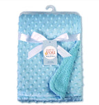 Light blue, plush baby blanket with a textured dot pattern, tied with a white ribbon and Just To You brand tag.