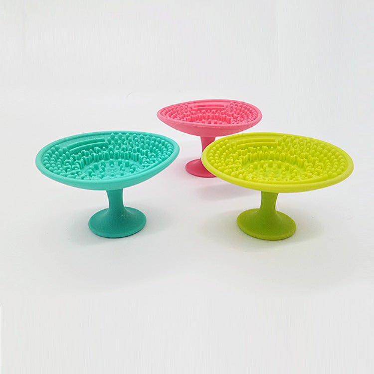 Three silicone makeup brush cleaning pads in teal, pink, and lime green, each with a suction cup base and textures.