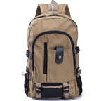 Tan canvas student backpack with black trim, multiple zippered compartments, side mesh pockets, and buckled straps.