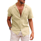 A tan, short-sleeve button-down beach shirt with a camp collar, made of a textured, linen-like fabric.