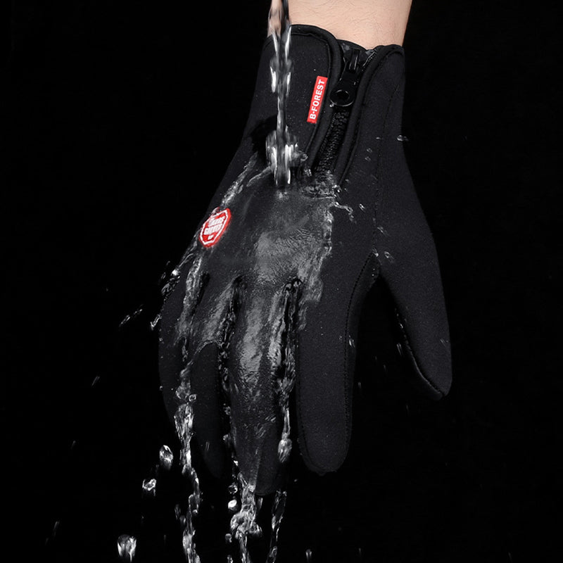 Waterproof black winter sports glove being sprayed with water, featuring a zipper closure and red logo tag.