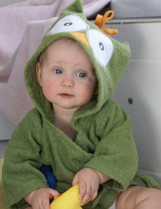 Baby wearing a green cotton hooded bathrobe with a cartoon owl face design and orange felt tuft.