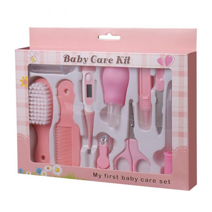 Pink boxed baby care kit with plastic grooming and health tools including a thermometer, brush, comb, and nail set.