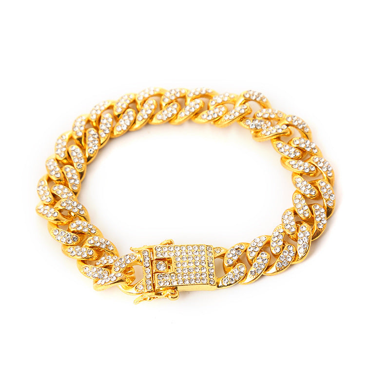Gold-toned cuban link chain bracelet paved with sparkling white rhinestones and a secure box clasp closure.