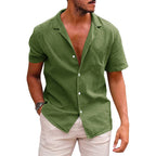 A man wearing an olive green, short-sleeved, button-down linen beach shirt with a notched collar.