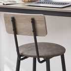 Grey PU leather bar stool with backrest, wooden back panel, and black metal frame under a matching bar table.