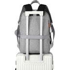 Grey fabric travel backpack with luggage strap, black padded straps, and zipper detail, mounted on a white suitcase.