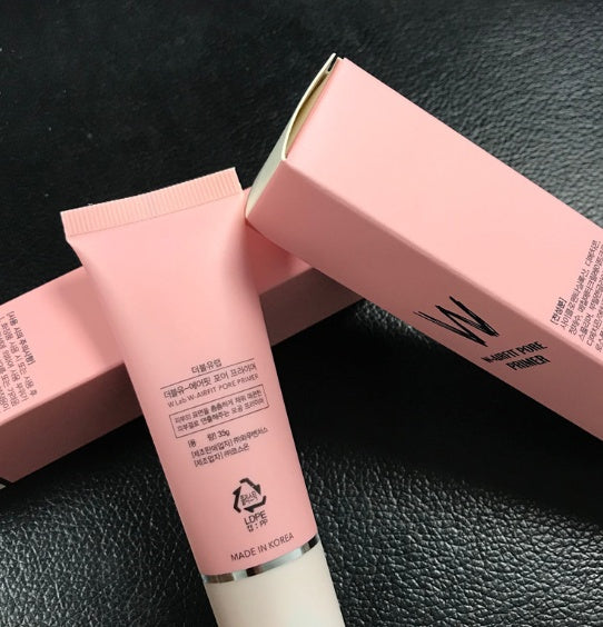 Pink W.Lab Airfit Pore Primer tube and box featuring black text on a textured black background. Made in Korea.