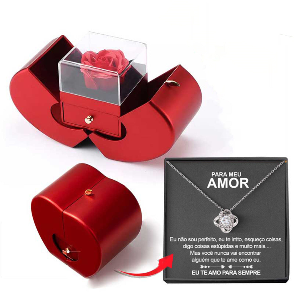 Red heart-shaped jewelry box with an eternal red rose, pull-out drawer, and a silver necklace on a Portuguese note card.