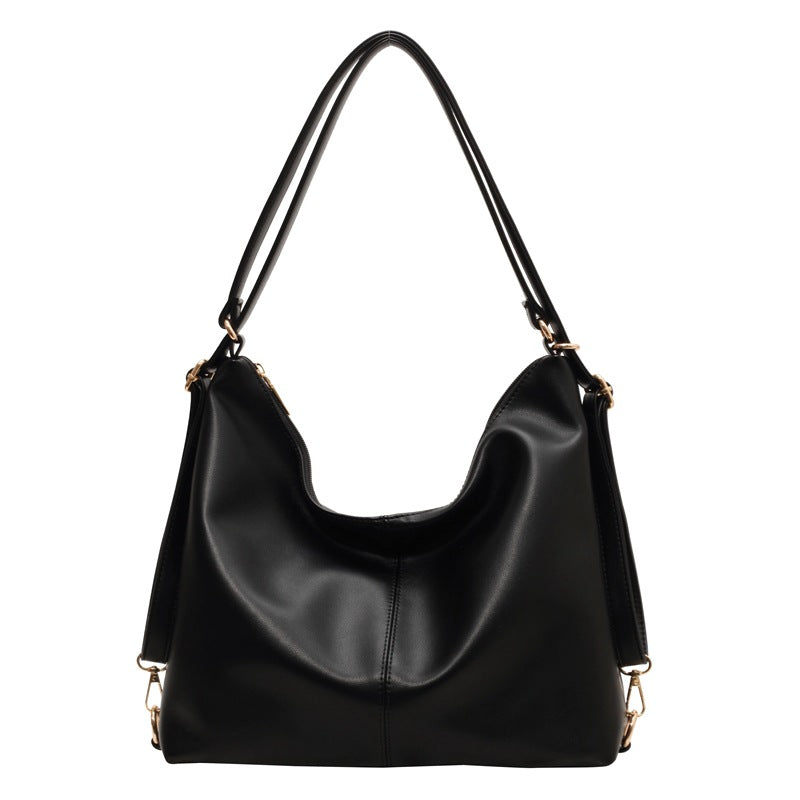 Elegant black PU leather slouchy shoulder bag with gold-tone hardware and a minimalist, vintage-inspired design.