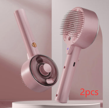 Two pink plastic steam pet grooming brushes with metal bristles on a white circular stand against a pink background.